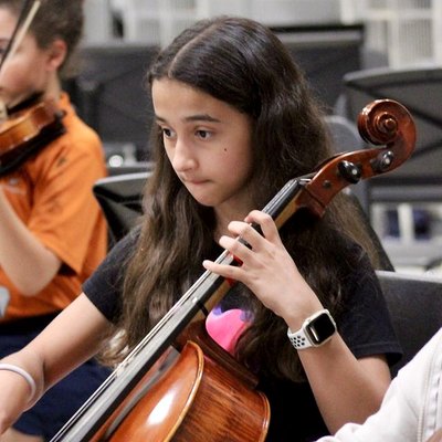 A young cellist concentrates during rehearsal